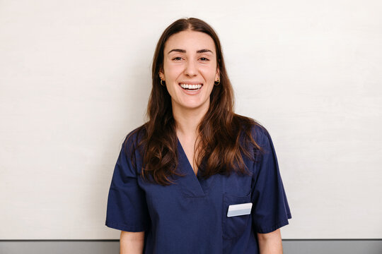 Friendly female healthcare worker in blue scrubs
