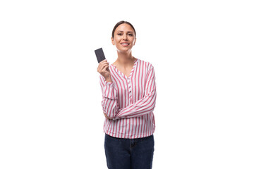 young brunette business woman dressed in a striped shirt shows a plastic credit card