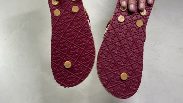 Close-up view 4k stock video footage of new pair of soft and flexible eva slippers in hands of woman