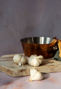 Fresh garlic on a sunlit table with kitchenware