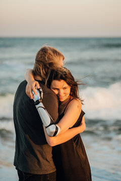 Loving young couple hugging at the ocean beach during the sunset