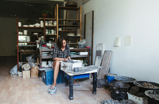 Female Potter Shaping Clay in Studio