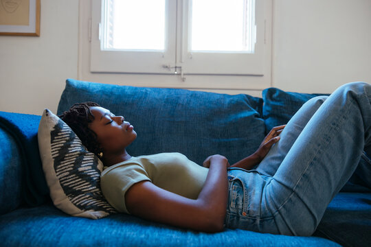 Woman sleeping on blue sofa