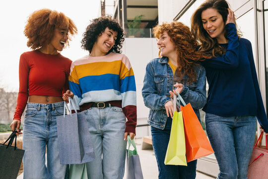 Joyful friends enjoying a shopping spree outdoors