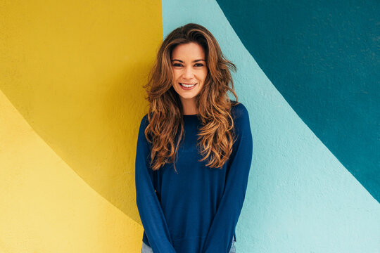 Fototapeta Smiling woman against a colorful geometric background