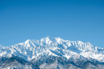 The mountains are covered in snow and the sky is clear and blue