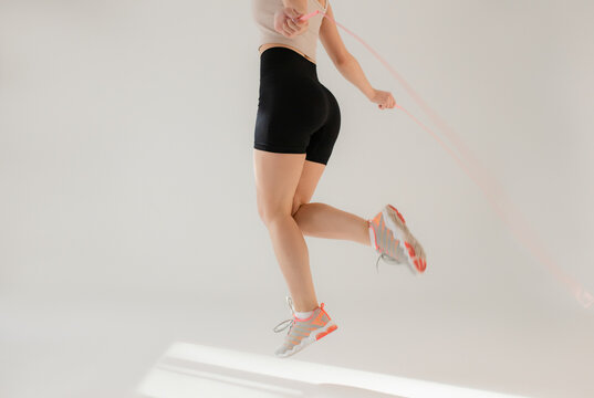 Jumping rope in a white studio background.
