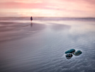 Rocks in water at beach during sunset