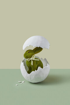 Artificial rabbit standing between two parts of chicken egg shells