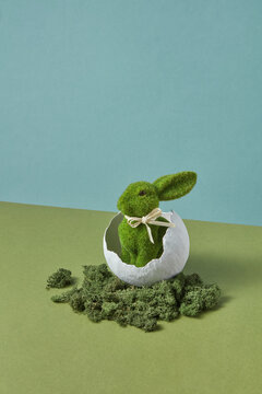 Easter rabbit with grass fur sitting in white bowl surrounded by moss