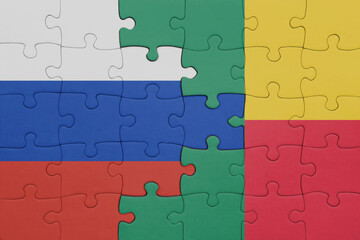 puzzle with the colourful national flag of benin and flag of russia.