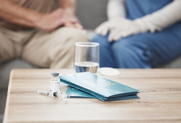 Nurse, pamphlet and covid vaccine on table in home for health education or awareness in living...