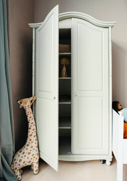 Toy Giraffe Next to White Cabinet