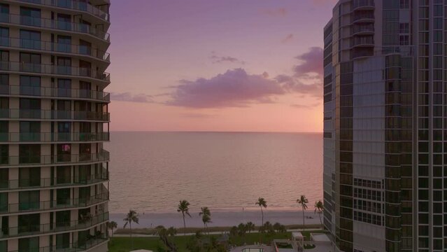 Naples Florida sunset beach reveal with tall apartment buildings. 