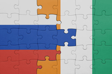 Fototapeta premium puzzle with the colourful national flag of cote divoire and flag of russia.