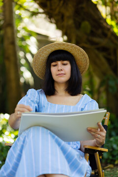 Happy woman artist drawing on white paper