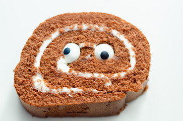 Chocolate sponge roll with a vanilla flavour filling with decorating sweet eyes, chocolate swiss roll