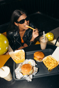 Woman eating french fries at a burger restaurant