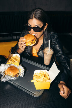 Stylish woman eating burger