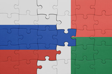 puzzle with the colourful national flag of madagascar and flag of russia.