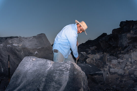 Worker moving rock in mine