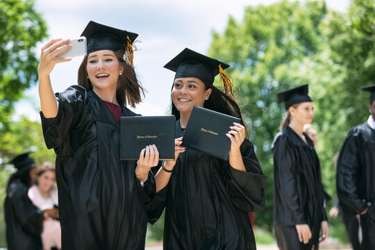 Grad: Two Friends Take Photo With Diplomas