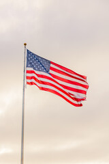 American flag waving against a cloudy sky