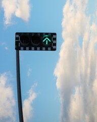 a traffic light with a blue sky in the background and clouds above