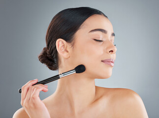Young woman, gray background and beauty with blusher for facial transformation, skincare or...