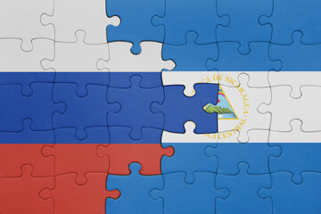 Fototapeta premium puzzle with the colourful national flag of nicaragua and flag of russia.