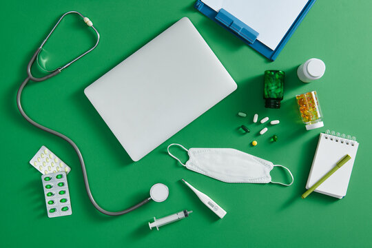 Medical stethoscope lying on cardiogram chart with pile of pills