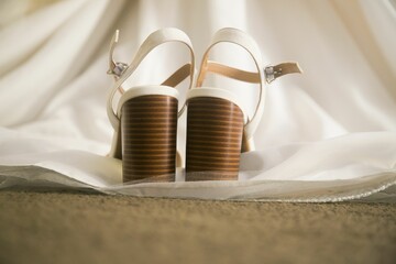 Closeup shot of white high heels on a bridal gown