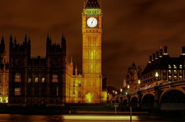 Obraz premium Nighttime view of Big Ben and Parliament with an illuminated bridge in London
