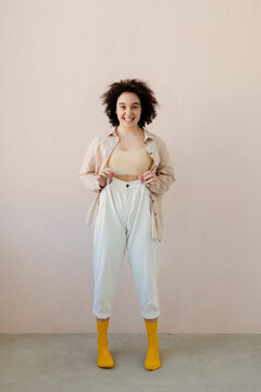Young Woman Posing in Casual Attire Against Neutral Background