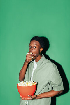 Young man eating popcorn