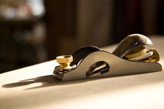 Wood shavings fly from a plane tool during woodworking 