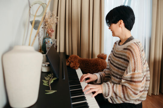 Woman Playing Piano With Dog Companion