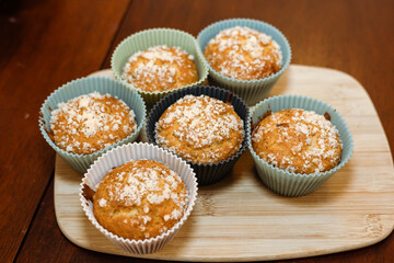 Muffins on wooden board dusted with powdered sugar