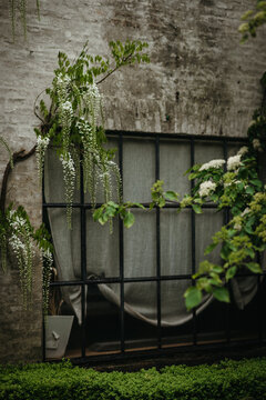 Old vintage paneled window in faded white brick house