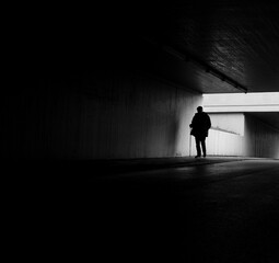 Black and white shot of an old man in a tunnel.