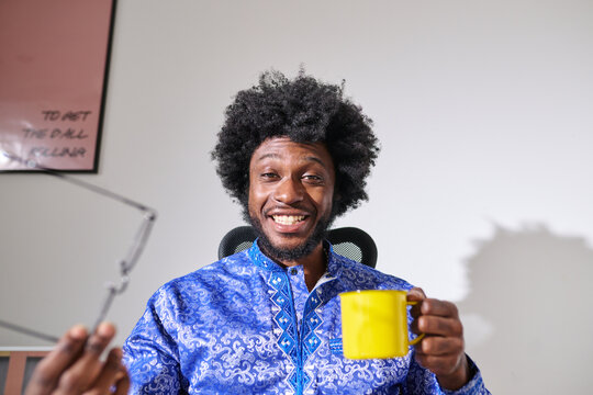 Smiling Businessman with Mug and Glasses during video call