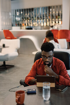 Thoughtful Entrepreneur Reviewing Plans at Lounge Workspace