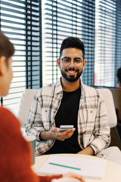 Male Entrepreneur Networking on Smartphone in Office Setting