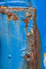 the door to an old blue painted garage with rust on it