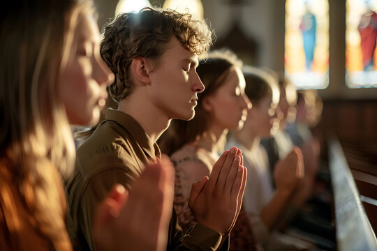 A young guy prays in a church with parishioners