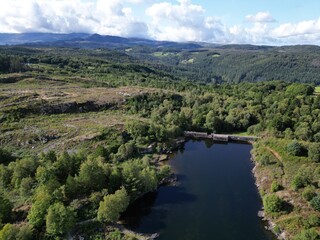 Obraz premium Aerial view of a lake encircled by lush green foliage