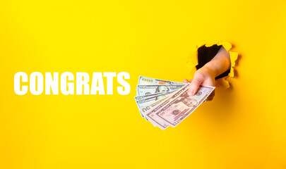 A hand holding a stack of money with the words Congratulations written below