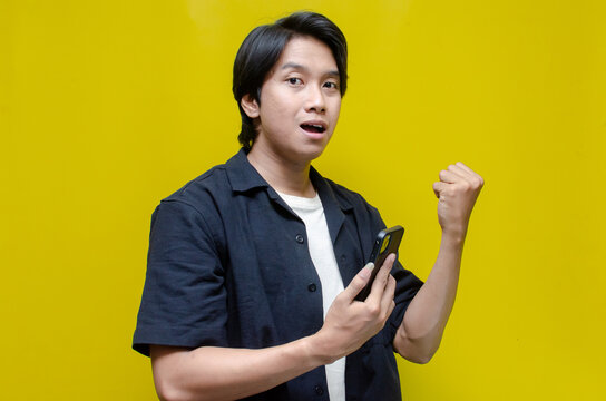 young asian man shocked covering his face after receiving unwanted news from his phone. asian man shocked watching his phone.