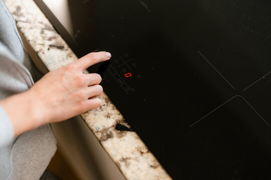 The woman turns on the stove