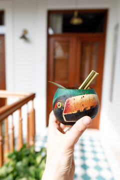 Parrot cup with cocktail in woman's hand